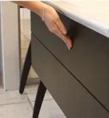 Minimalistisk och stilren badrumsinspiration med tvättställsskåp, underskåp och högskåp i gyllene ek, stor rund spegel med ljusreglering, färgad toalett och fristående handfat