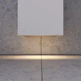 Litet stilrent badrum med mörkblå väggar, mjuka gula badrumsmöbler med ribbor, och elegant rund spegel med lampa