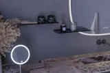 Stor badrumsinspiration med grå underskåp med integrerat handtag, snyggt sidomonterat handfat, fyrkantig spegel med rundade hörn, väggar i betonglook och råa material för en urban look
