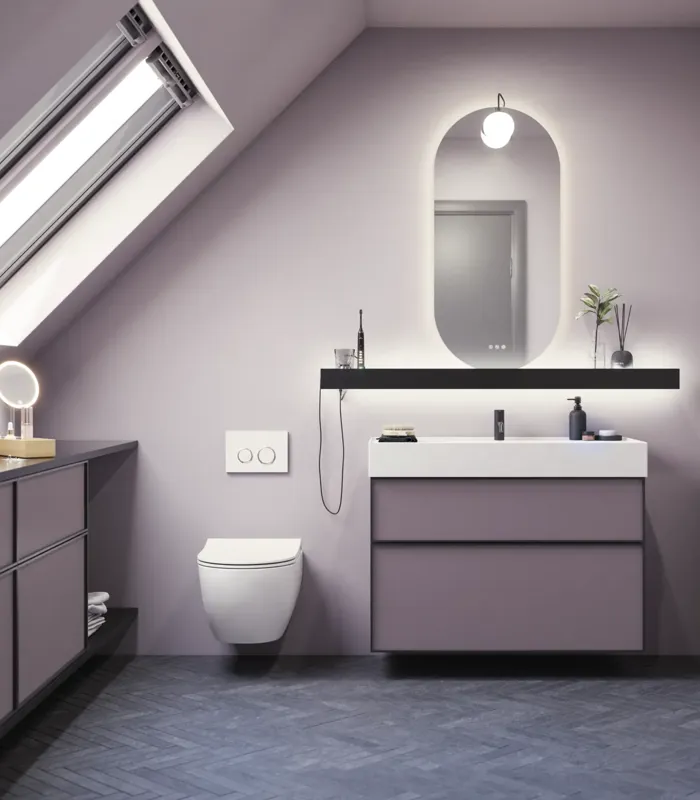 Badrum med snedtak inspiration, med badrumsmöbler i lila med eleganta ramfronter, vacker oval spegel med lampa, snygg och praktisk hylla, samt lilamålad vägg och grått fiskbensgolv som ger ett elegant och modernt uttryck.