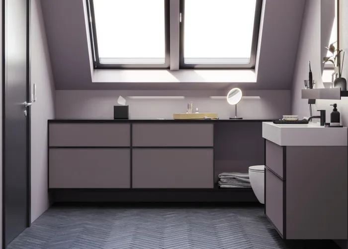 Badrum med snedtak inspiration, med badrumsmöbler i lila med eleganta ramfronter, vacker oval spegel med lampa, snygg och praktisk hylla, samt lilamålad vägg och grått fiskbensgolv som ger ett elegant och modernt uttryck.