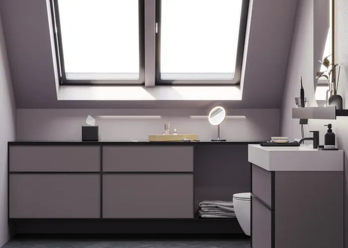 Badrum med snedtak inspiration, med badrumsmöbler i lila med eleganta ramfronter, vacker oval spegel med lampa, snygg och praktisk hylla, samt lilamålad vägg och grått fiskbensgolv som ger ett elegant och modernt uttryck.