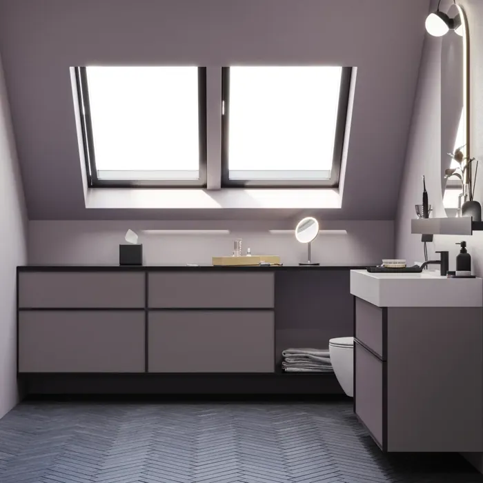 Badrum med snedtak inspiration, med badrumsmöbler i lila med eleganta ramfronter, vacker oval spegel med lampa, snygg och praktisk hylla, samt lilamålad vägg och grått fiskbensgolv som ger ett elegant och modernt uttryck.