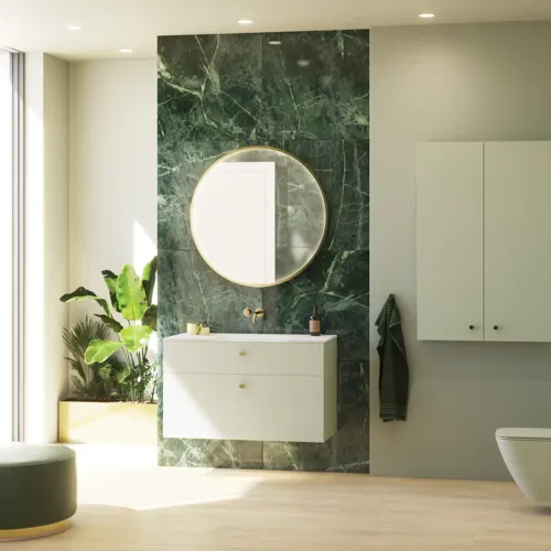 Stilrent och lyxigt badrum med mjuka gröna nyanser, en stor elegant rund spegel och en modern, sofistikerad grön toalett