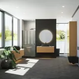 Minimalistisk och stilren badrumsinspiration med tvättställsskåp, underskåp och högskåp i gyllene ek, stor rund spegel med ljusreglering, färgad toalett och fristående handfat