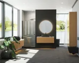 Minimalistisk och stilren badrumsinspiration med tvättställsskåp, underskåp och högskåp i gyllene ek, stor rund spegel med ljusreglering, färgad toalett och fristående handfat