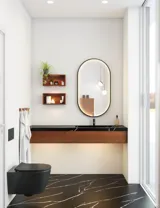 Modern och stilren badrumsinspiration med oval spegel med svart ram och ljusreglering, färgad toalett, tvättställsskåp, underskåp och skåp i rödbrun ek, Silestone handfat och matchande golv