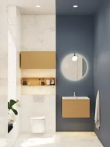 Litet, stilrent badrum med mörkblå väggar, mjuka gula badrumsmöbler med ribbor, och elegant rund spegel med lampa