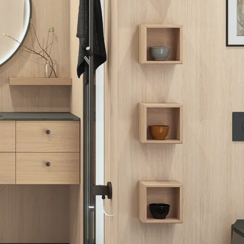 Stilrent badrum i skandinavisk och japandi inredningsstil med ljusa träväggar, rund spegel och minimalistiska badrumsmöbler