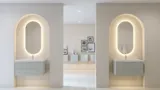 Stilfull och modern badrumsinspiration med ovala speglar med ljusreglering, stenhandfat och tvättställsskåp med fina och eleganta räfflor i en minimalistisk design, badrummet har en ljus och luftig atmosfär med elegant belysning och raffinerade detaljer