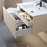 Stilfull badrumsinspiration med beige tvättställsskåp med innerskiva, överskåp, öppen hylla, ovalt spegel med belysning, matchande pendellampor, hylla under spegeln och vägghängd toalett. Väggar med ljusa, avlånga kakelplattor