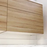 Nordiskt badrum i trä med vackra runda speglar med svarta kanter och gott om förvaring i badrumsmöblerna