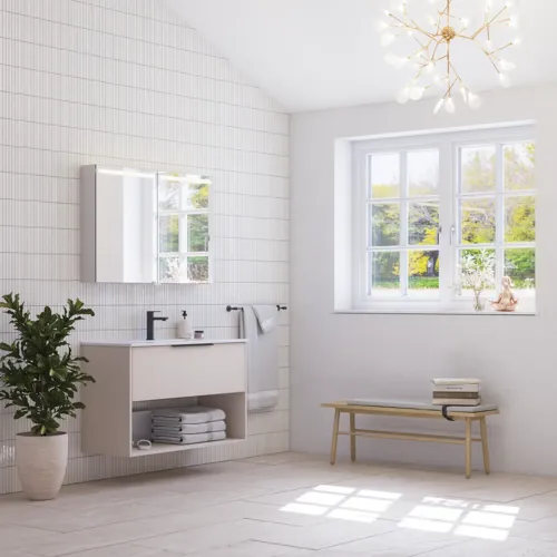 Stor badrumsinspiration med små avlånga plattor, feminin ljuskrona, elegant underskåp och högskåp i ljusbeige med vackra smala ränder, svarta moderna avlånga handtag och snyggt spegelskåp med belysning för att skapa en romantisk atmosfär.