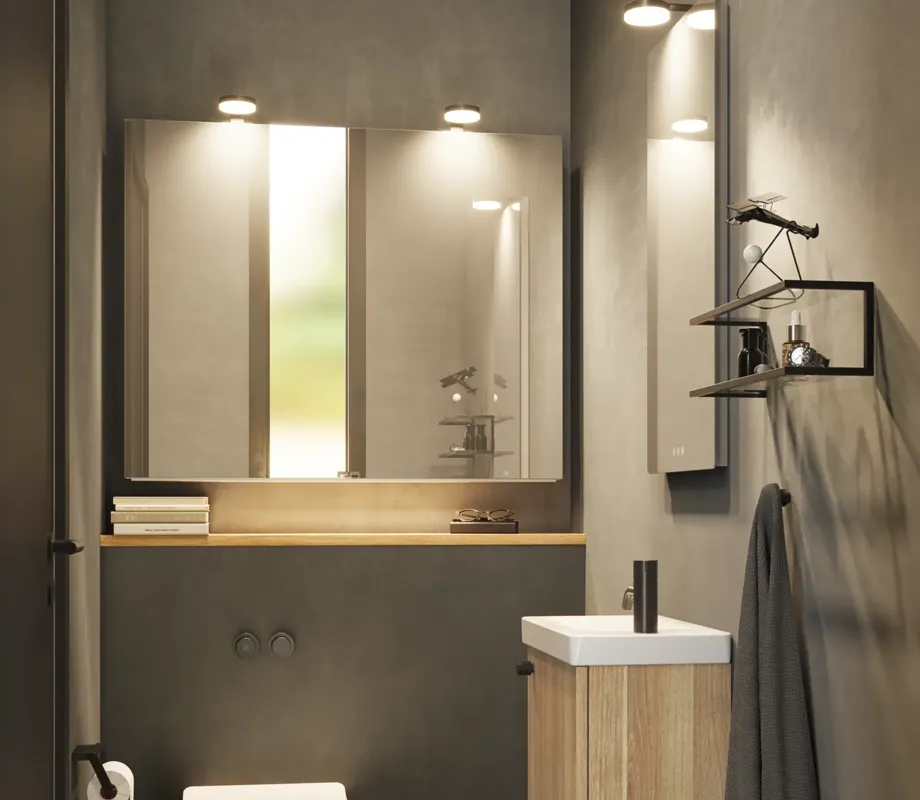 Stilren och minimalistisk badrumsinspiration med mikro tvättställ och litet tvättställsskåp, fyrkantig spegel med rundade hörn och lampa, samt elegant spegelskåp.