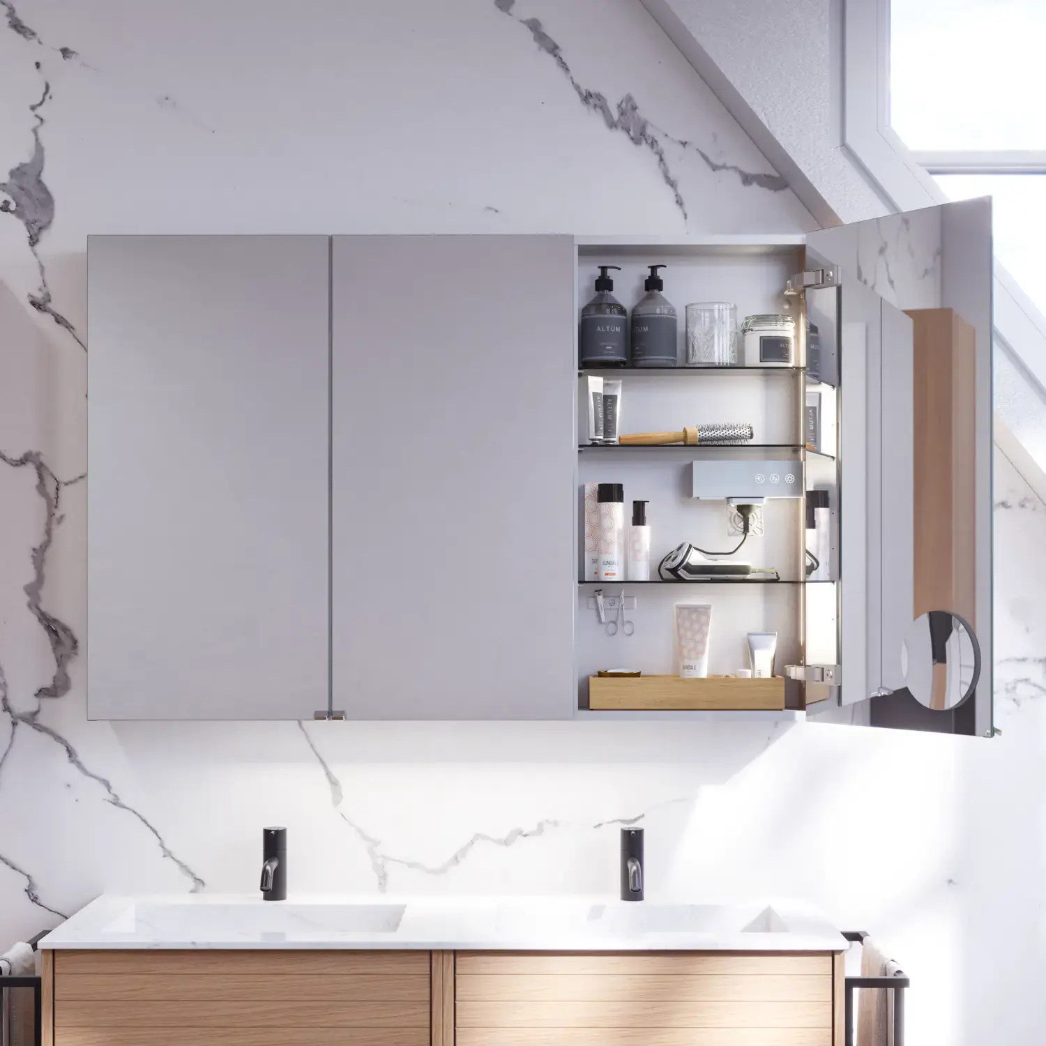 Badrumsinspiration med tvättställsskåp samt överskåp i ljus ek med räfflor, elegant dubbel handfat, vackert spegelskåp med ljus, fiskbensgolv i ljust trä och vit marmorerad vägg ger ett klassiskt, ljust och stilrent utseende.