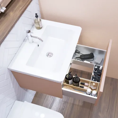 Liten badrumsinspiration med tvättställsskåp i specialfärg med integrerat grepp, spegelskåp med lampor, dekorationsspeglar med tonad glashylla, vita fiskbensplattor ger ett stilrent och klassiskt utseende.