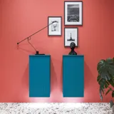 Stor badrumsinspiration med badrumsmöbler i blå specialfärg med räfflor, tunn elegant handfat samt vackra runda speglar, röda väggar och terrazzogolv skapar en stor kontrast till möblerna och ger ett stiligt och urbant utseende.