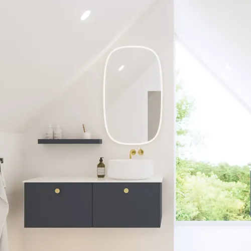 Elegant och modern badrumsinspiration med snedtak, väggmonterade blå tvättställsskåp och underskåp, rund handfat med mässingsarmatur, belyst spegel och naturligt ljusinsläpp
