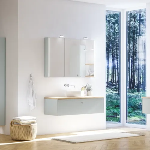 Stor badrumsinspiration i nordisk stil med badrumsmöbler i ljusblå färg och träbänkskiva med elegant fristående handfat, fiskbensgolv i trä som skapar en ljus och klassisk stil