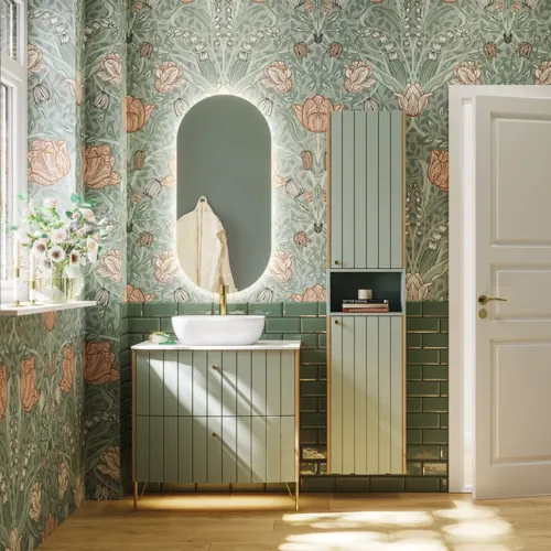 Badrumsinspiration med badrumsmöbler i grön specialfärg med sidor i naturlig ek, eleganta räfflor, stilfull bänkskiva med romantiskt ovalt bordsmonterat handfat, vacker oval spegel, ger tillsammans med blommigt tapet ett graciöst, vintage retro utseende.