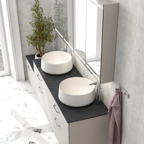 Romantisk badrumsinspiration med spegelskåp som har praktiska och eleganta förvaringslösningar, dubbla fristående handfat på en stenskiva.