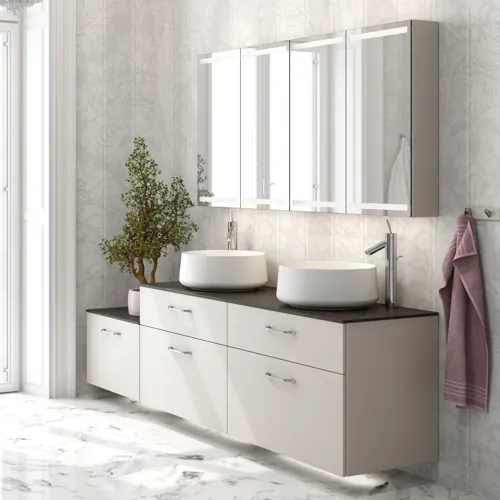 Romantisk badrumsinspiration med spegelskåp som har praktiska och eleganta förvaringslösningar, dubbla fristående handfat på en stenskiva.