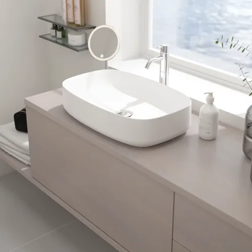Liten badrumsinspiration med bänkskiva på mått, elegant fristående handfat och fyrkantig figurspegel som skapar ett ljust och modernt rum.