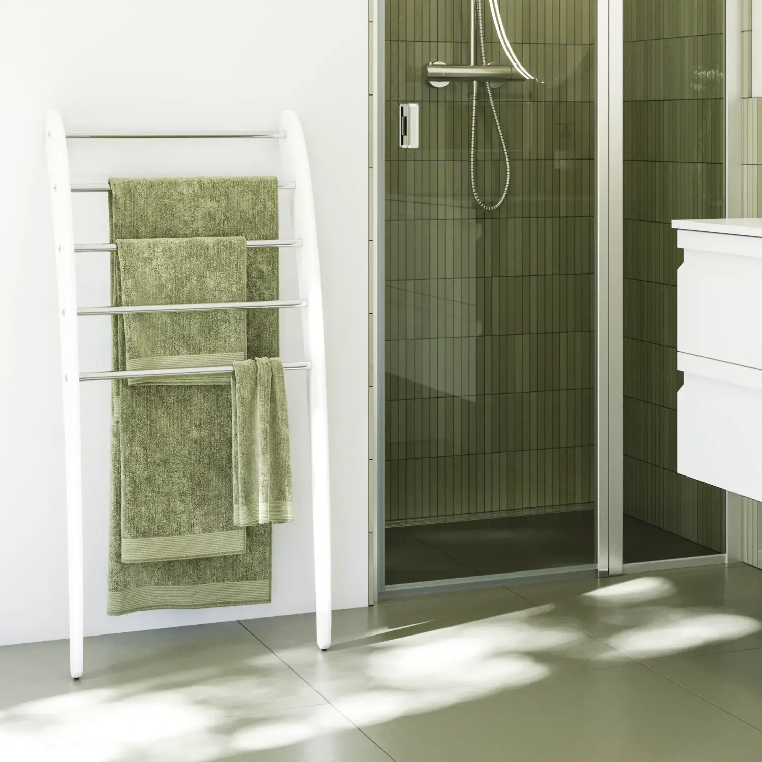 Badrumsinspiration med vita badrumsmöbler, elegant rund spegel och duschnisch med fast duschvägg med slagdörr i klart glas och profiler i satin, grönt avlångt kakel ger en sofistikerad look.