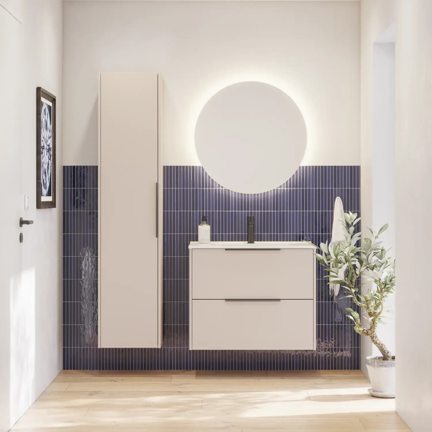 Badrumsinspiration med avlångt blått kakel, elegant beige underskåp och högskåp med svarta, minimalistiska och avlånga handtag samt en rund spegel med ljus för en vacker och kontrasterande look.