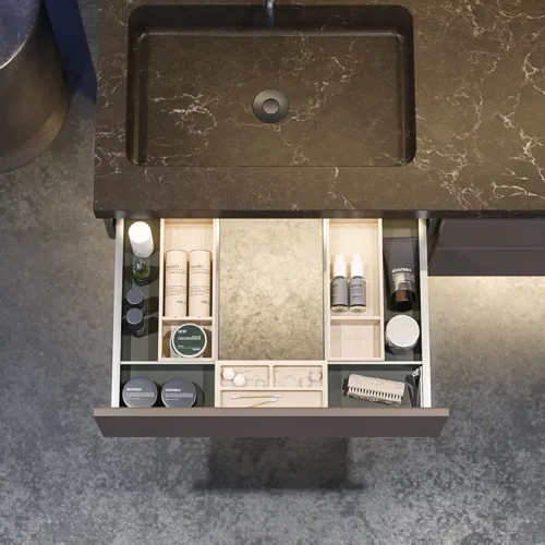 Stilrent och rymligt badrumsinspiration med stor rund spegel med svart ram, mörk stenhandsfat, färgad toalett, överskåp och öppen hylla i en sofistikerad och dämpad design.