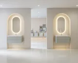 Stilfull och modern badrumsinspiration med ovala speglar med ljusreglering, stenhandfat och tvättställsskåp med fina och eleganta räfflor i en minimalistisk design, badrummet har en ljus och luftig atmosfär med elegant belysning och raffinerade detaljer.