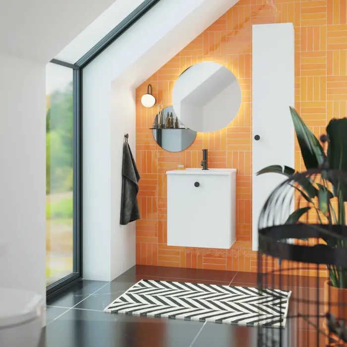 Badrum med snedtak inspiration med liten vit kommod och högskåp med runda svarta handtag, samt vacker rund spegel, orange kakel ger ett fräscht och modernt utseende.