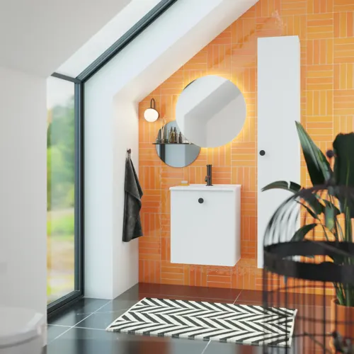 Badrum med snedtak inspiration med liten vit kommod och högskåp med runda svarta handtag, samt vacker rund spegel, orange kakel ger ett fräscht och modernt utseende.
