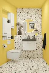 Liten badrumsinspiration med vitt tvättställsskåp med svart handtag och svart elegant handfat, vacker rund spegel med svart kant, förskjutna överskåp samt terrazzo vägg och golv och gula väggar ger ett modigt och modernt utseende.