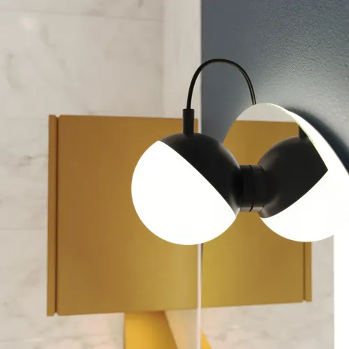 Lampa till spegel med mjuka former på mörkblå vägg i stilrent badrum.