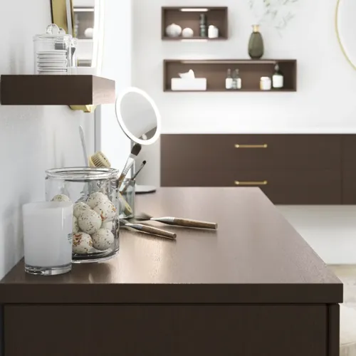 Nordisk stil badrumsinspiration med tvättställsskåp och underskåp i rökt ek, sminkplats, sidoplacerat handfat, rund spegel med mässingsram och synliga charmiga träbjälkar.