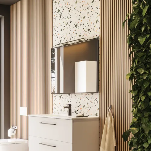 Stor badrumsinspiration med badrumsmöbler i mattvitt med elegant handfat och fyrkantig spegel med svart kant och lampa, terrazzo vägg och golv och växter på väggen för en modern och sofistikerad look.