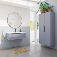 Badrumsinspiration med avlånga ljusblå kakelplattor och betonggolv, elegant tvättställsskåp i ljusblått med vackra smala ränder, stilren och tunn handfat, dubbelt högskåp med smala ränder, samt en minimalistisk rund spegel med svart kant och belysning.