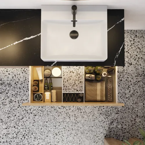 Stor urban badrumsinspiration med möbler i naturlig ek, stenbänkskiva med fyrkantig vask, runt spegel med svart kant, naturfärger och terrakottagolv ger en industriell och modern känsla