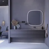 Stor badrumsinspiration med grå underskåp med integrerat handtag, snyggt sidomonterat handfat, fyrkantig spegel med rundade hörn, väggar i betonglook och råa material för en urban look