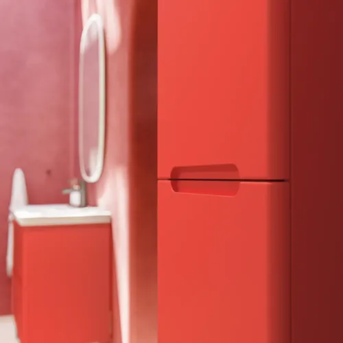 Badrumsinspiration med röda väggar, mjukt formade röda tvättställsskåp och högskåp, elegant vit handfat och en vacker oval spegel med ljus som tillsammans med den naturliga omgivningen skapar en vintagekänsla