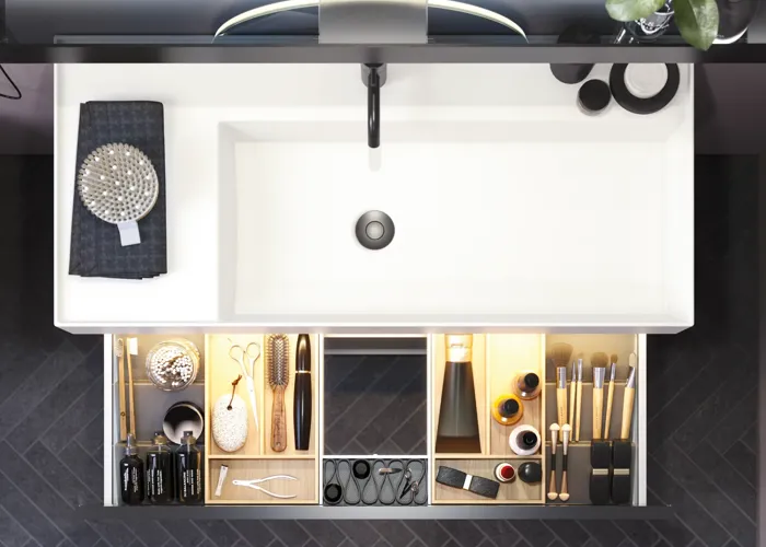 Badrum med snedtak inspiration, med badrumsmöbler i lila med eleganta ramfronter, vacker oval spegel med lampa, snygg och praktisk hylla, samt lilamålad vägg och grått fiskbensgolv som ger ett elegant och modernt uttryck.